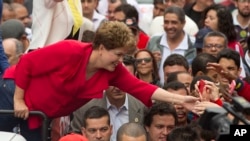 Presiden Brazil dan kandidat presiden dari Partai Buruh, Dilma Rousseff, menyapa para pendukungnya dalam kampanye di Sao Paulo (20/9). (AP/Andre Penner) 