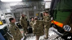 FILE - British military personnel gathered next to a French army truck inside a British C17 transport plane at an army base in Evreux, 90 kms (56 miles) north of Paris, Jan. 14, 2013. 
