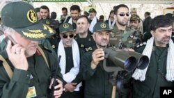 In this photo released by the semi-official Iranian Fars News Agency, Iranian Revolutionary Guard commander Mohammad Ali Jafari, center, monitors maneuvers by the Iranian Revolutionary Guard, near the Strait of Hormuz, 24 Apr 2010