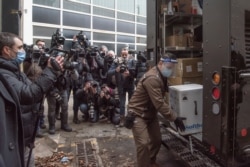 A box of Pfizer/BioNTEch COVID-19 vaccine is delivered from a UPS truck past news photographers to the Maimonides long term care home in Montreal, Quebec, Canada, Dec. 14, 2020. (Courtesy Quebec Ministry of Health and Social Services)