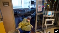 FILE - In this Aug. 17, 2021, photo, an ICU nurse moves electrical cords for medical machines outside the room of a COVID-19 patient in an intensive care unit at the Willis-Knighton Medical Center in Shreveport, La. 