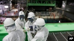 Para insinyur TEPCO mengenakan baju pelindung radiasi untuk memulai pekerjaan berbahaya di Fukushima (foto: dok). 