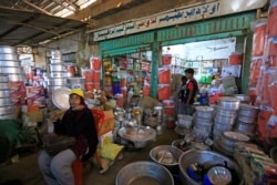 FILE - People shop at a street market in the Sudanese capital's twin city of Omdurman, July 8, 2020.