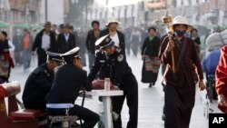 一名藏族小贩走过拉萨街头的中国警察身边走过