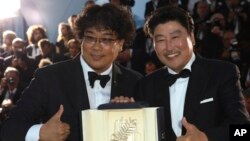 Actor Kang-Ho Song, right, and director Bong Joon-ho pose with the Palme d'Or award for the film "Parasite" following the awards ceremony at the 72nd international film festival in Cannes, France, May 25, 2019.