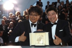 Actor Kang-Ho Song, right, and director Bong Joon-ho pose with the Palme d'Or award for the film "Parasite" following the awards ceremony at the 72nd international film festival in Cannes, France, May 25, 2019.