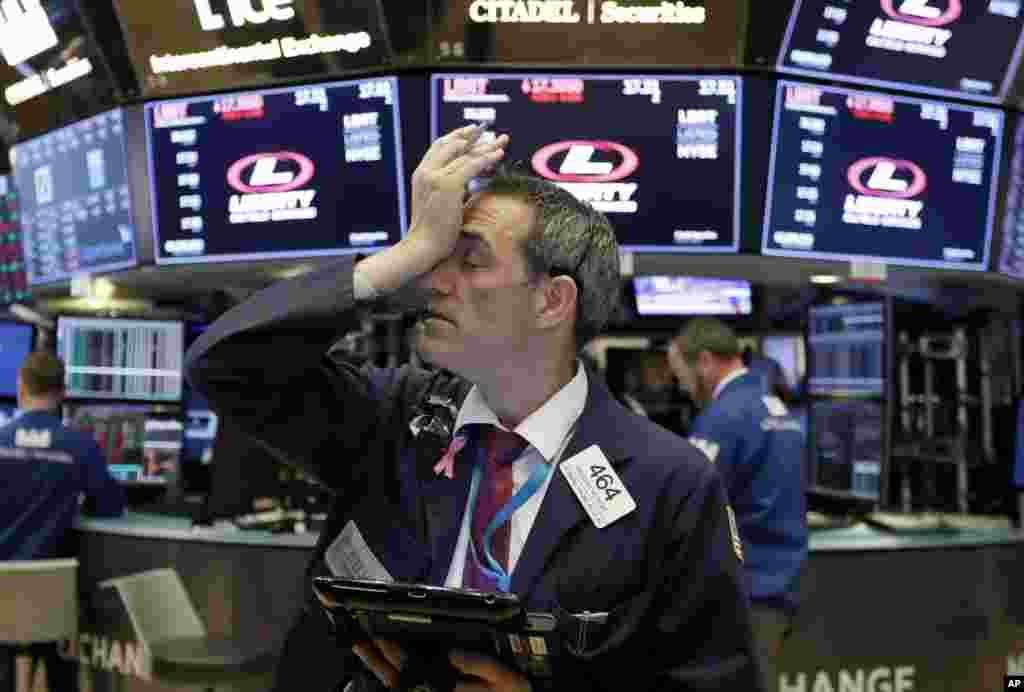 Trader Gregory Rowe works on the floor of the New York Stock Exchange. Stocks are opening sharply lower on Wall Street following big drops in Asia and Europe.