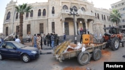 People gather around the scene of a bomb explosion in front of of al-Hijaz train station in central Damascus, Nov. 6, 2013, in this handout picture released by SANA.