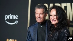 FILE - Randy Travis, left, and his wife, Mary, arrive at the 58th annual Academy of Country Music Awards on Thursday, May 11, 2023, at the Ford Center in Frisco, Texas. (AP Photo/Jeffrey McWhorter)
