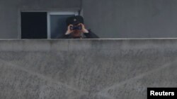 A North Korean soldier looks through a pair of binoculars at the Yalu River in Sinuiju, North Korea, which borders Dandong in China's Liaoning province, April 15, 2017.