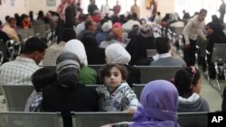 FILE - Syrian refugee families wait to be registered with the UNHCR services, during the Australian Foreign Minister Julie Bishop's visit to the compound, to meet with the UNHCR representative to Jordan, Andrew Harper, regarding the Syrian refugee situation, in Amman, Jordan, April 21, 2014. 