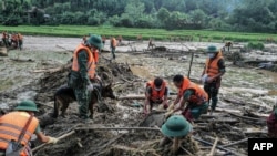 Nhân viên cứu hộ tại một vùng đất trùi tại một làng thuộc tỉnh Lào Cai sau bão Yagi, 12 tháng Chín.