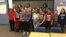 La primera dama de EE.UU. Melania Trump (centro atrás) y la secretaria de Educación Betsy DeVos (primera de atrás a la izquierda) posan con estudiantes de la escuela secundaria Orchard Lake, en Michigan, durante visita para hablar sobre la inclusión. Foto: @OLMS_Vikings.