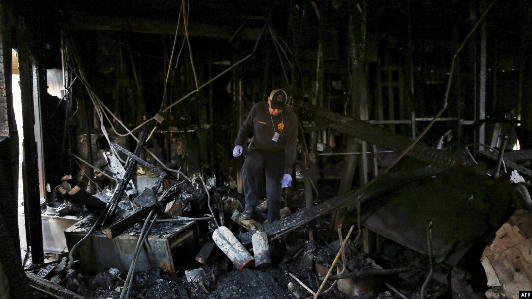 Petugas pemadam kebakaran kota Houston, AS memeriksa lokasi Quba Islamic Institute di Houston, Texas yang hangus terbakar (13/2).