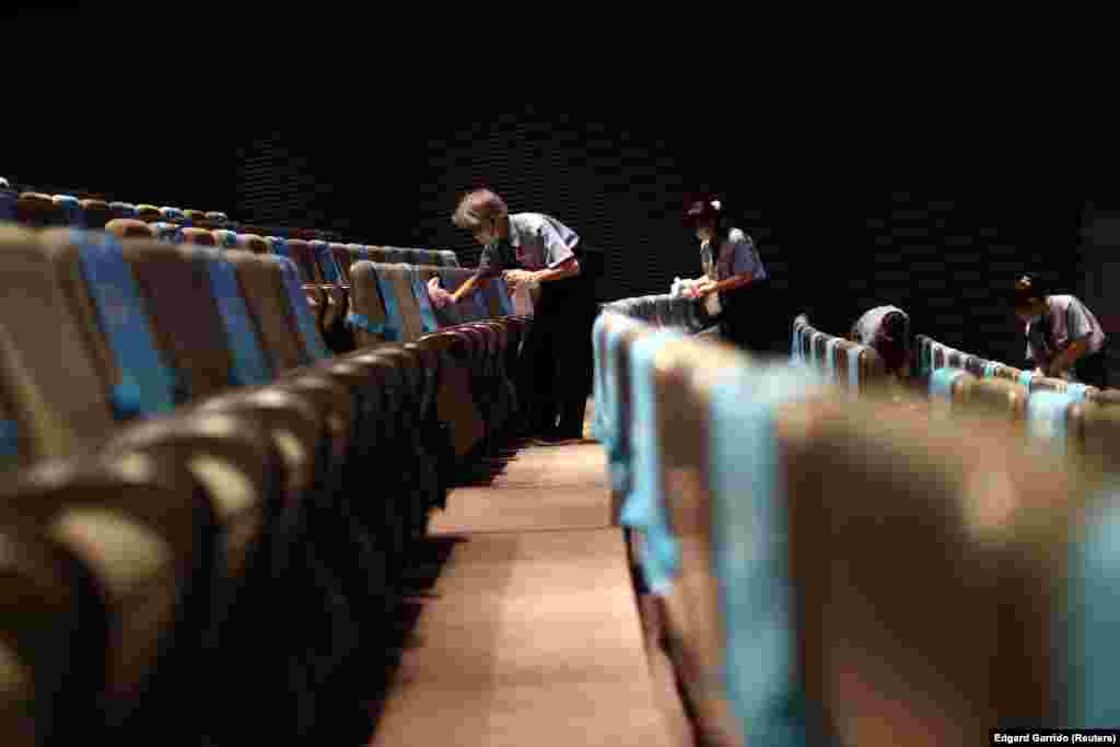 Jogos Olímpicos 2020 - Empregados desinfectam cadeiras durante intervalo de competição de halterofilismo em Tóquio