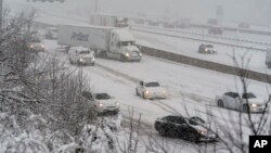 El tráfico se desliza al subir una pequeña colina en la I-495, Capital Beltway, mientras cae la nieve, el 3 de enero de 2022 en Fort Washington, Maryland, EE. UU.