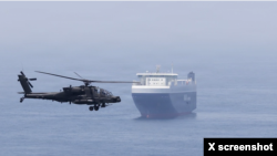 미군의 입체적인 호위 작전 아래, 미 육군 아파치(AH-64) 공격헬기가 호르무즈 해협을 통과하는 대형 민간 화물선 옆을 비행하며 근접 경계 임무를 수행하고 있다. (출처: 8월 27일 미 중부사령부 X  브리핑 영상 캡처. 자료사진)