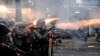 Police officers fire tear gas launchers during a clash with student protesters in Bandung, West Java, Indonesia.&nbsp;Thousands of students and workers protested against a new law they say will cripple labor rights and harm the environment.