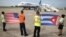 FILE - Ground crew hold U.S. and Cuban flags near a recently landed JetBlue aeroplane, the first commercial scheduled flight between the United States and Cuba in more than 50 years, in Santa Clara, Cuba, Aug. 31, 2016.