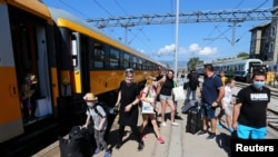 FILE - Tourists exit a train on the first direct train service from Prague to Rijeka, at the station in Rijeka, Croatia, July 1, 2020.