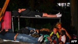 Una mujer sentada con un niño llorando mientras migrantes hondureños, parte de una caravana que se dirige a Estados Unidos, descansan en Entre Ríos, Guatemala, luego de cruzar la frontera desde Honduras el 1 de octubre de 2020.