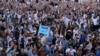 FILE - Members of Pakistan's Pashtun community chant slogans and take photos of their leader, Manzoor Pashteen (unseen), during a rally by the Pashtun Tahafuz Movement against alleged human rights violations, in Lahore, Pakistan, April 22, 2018.