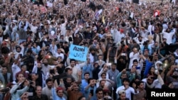 FILE - Members of Pakistan's Pashtun community chant slogans and take photos of their leader, Manzoor Pashteen (unseen), during a rally by the Pashtun Tahafuz Movement against alleged human rights violations, in Lahore, Pakistan, April 22, 2018.