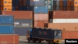 A truck ferries a shipping container at a port in the southern Indian city of Chennai, February 13, 2013.