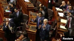 Lawmakers supporting Peru's President Pedro Pablo Kuczynski celebrate after Kuczynski defeated an opposition bid to force him from power in Congress in Lima, Peru, Dec. 21, 2017. 