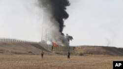 Palestinci stoje ispred osmatračnice izraelske vojske u pojasu Gaze (Foto: AP/Hatem Ali)