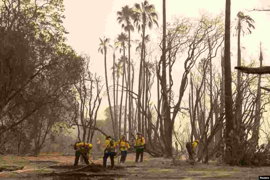 Firefighters extinguish hot spots from the Alisal fire near Refugio State Beach in Santa Barbara County, California, October 13, 2021.