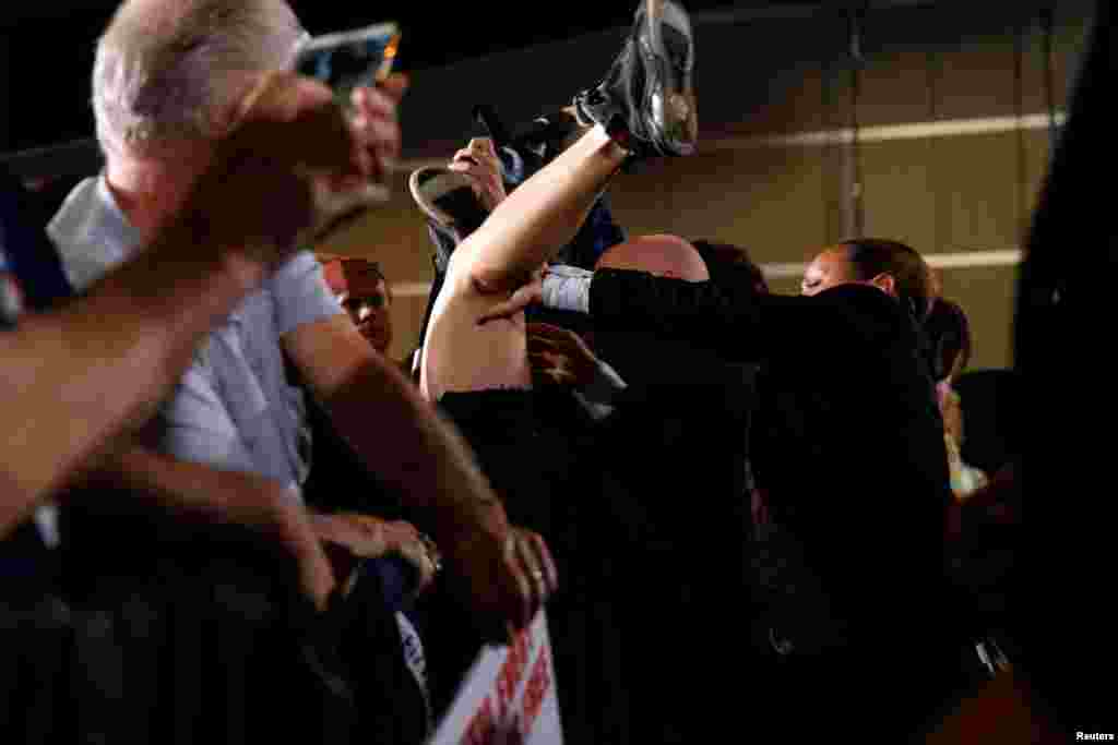 Secret Service agents push an animal rights activist out of a buffer area as Democratic U.S. presidential nominee Hillary Clinton speaks to International Brotherhood of Electrical Workers (IBEW), Local 357, union members during a rally at the IBEW union hall in Las Vegas, Nevada, August 4, 2016.