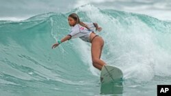 Luana Reis, 14, rides a wave during a local surf tournament in Maresias beach, Sao Sebastiao, Brazil, Nov. 26, 2021.