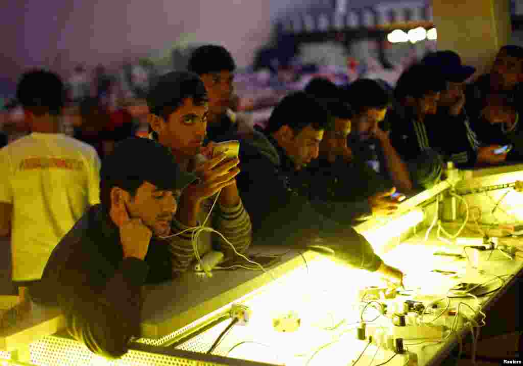 Migrants charge their mobile devices at an improvised shelter inside a concert hall in Wiesen, Austria,&nbsp; Sept. 13, 2015. (Reuters)