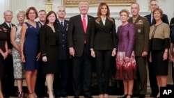 El presidente Trump y la primera dama, Melania Trump posa junto a un grupo de militares de alto rango y sus esposas durante una cena de gala en la Casa Blanca, el jueves 5 de octubre.