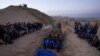Una excavadora descarga los cuerpos de palestinos muertos en combates con Israel y entregados por el ejército israelí durante un funeral masivo en Rafah, Franja de Gaza, el 26 de diciembre de 2023.