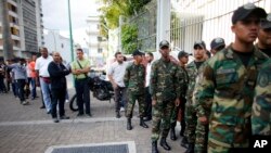 Venezuelan Bolivarian Army soldiers lineup to vote for the constitutional assembly outside of a poll station in Caracas, Venezuela, July 30, 2017. 