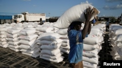 FILE - A man carries sacks of food aid for distribution to Internally displaced people (IDPs) in the POC (Protection of Civilians) Camp, run by the UN Mission in South Sudan near the town of Malakal, in the Upper Nile state of South Sudan.