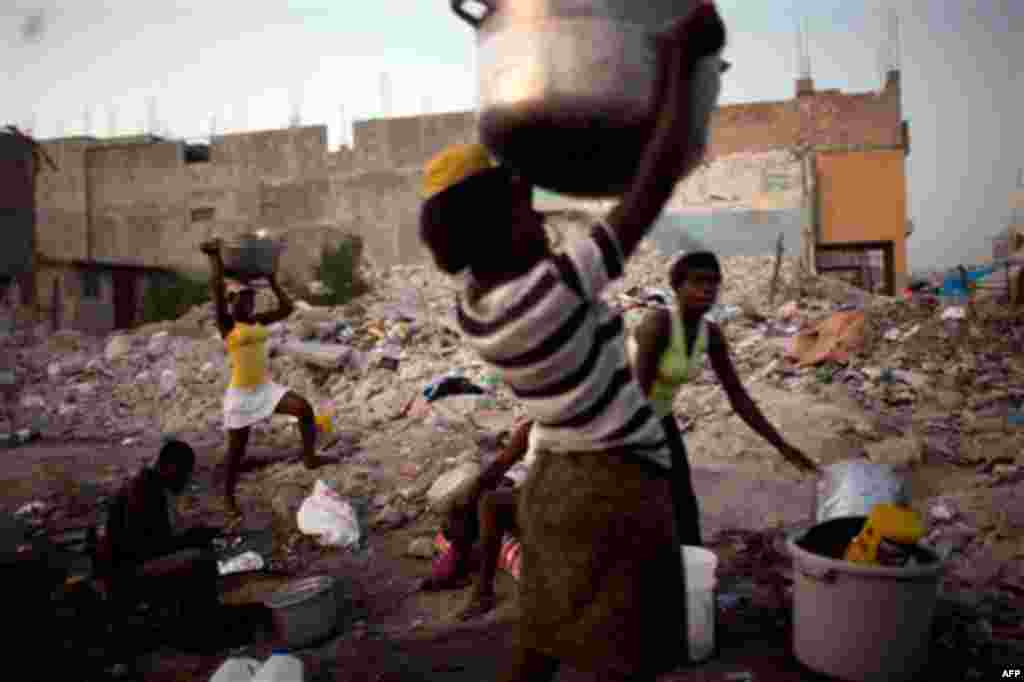 January 19: Food sellers prepare to carry their pots home at the end of their workday in downtown Port-au-Prince, Haiti. (AP/Rodrigo Abd)