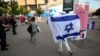 A supporter waves an Israeli flag as they arrive before the start of the men's group D football match between Mali and Israel during the 2024 Olympic Games in Paris on July 24, 2024. Iraq unsuccessfully asked Olympic officials not to display Israel's flag next to Iraq's. 