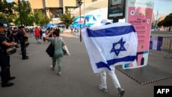 A supporter waves an Israeli flag as they arrive before the start of the men's group D football match between Mali and Israel during the 2024 Olympic Games in Paris on July 24, 2024. Iraq unsuccessfully asked Olympic officials not to display Israel's flag next to Iraq's. 