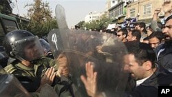 Iranian policemen prevent protesters from attacking the British Embassy in Tehran, during an anti-British demonstration, 04 Nov 2010