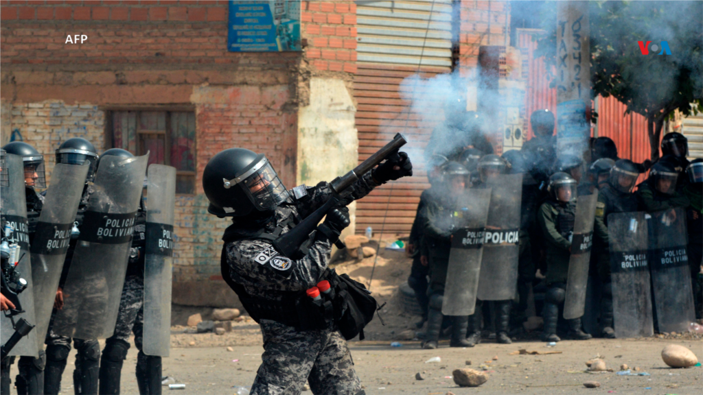 Un agente de la policía antidisturbios dispara gases lacrimógenos contra manifestantes que apoyan al expresidente Evo Morales durante un bloqueo de carreteras en Cochabamba, Departamento de Cochabamba, Bolivia.