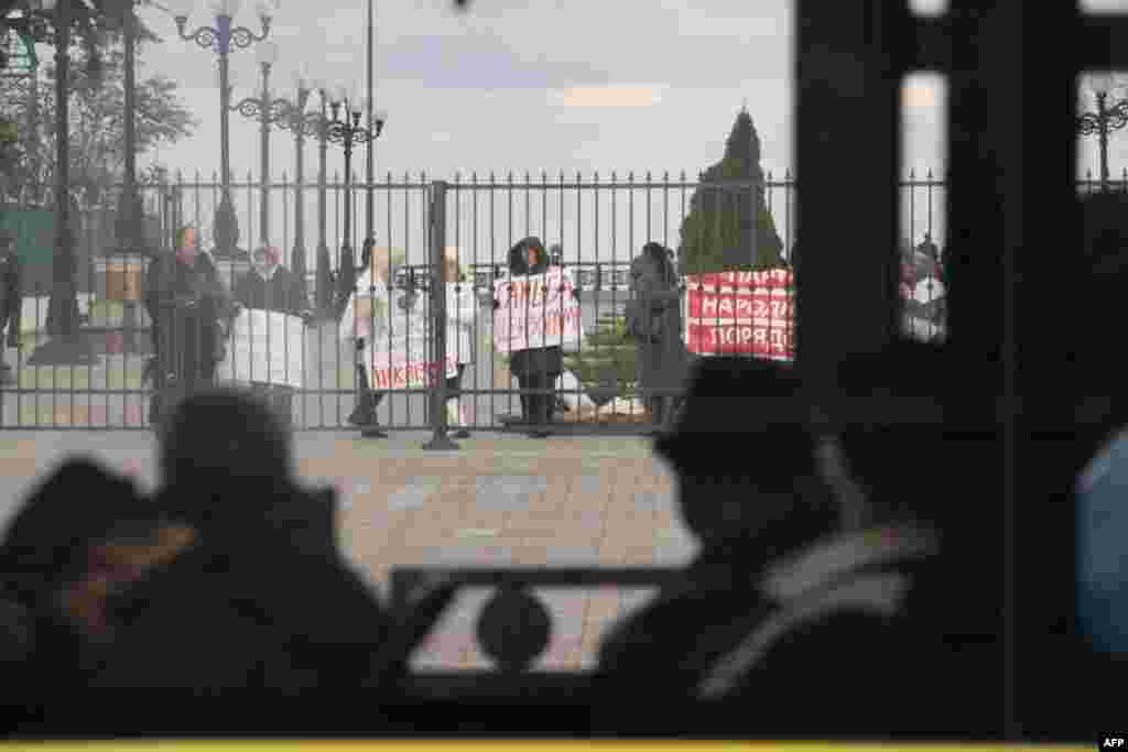 Пассажиры рейсового автобуса не обращают внимания на митинг под Верховной Радой