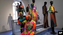 FILE - From left, designers Glen and Bruce Proctor pose for portraits in front of their creations at the fashion hub part of the women's Fall-Winter 2024-25 collection presented in Milan, northern Italy, Wednesday, February 21, 2024. 
