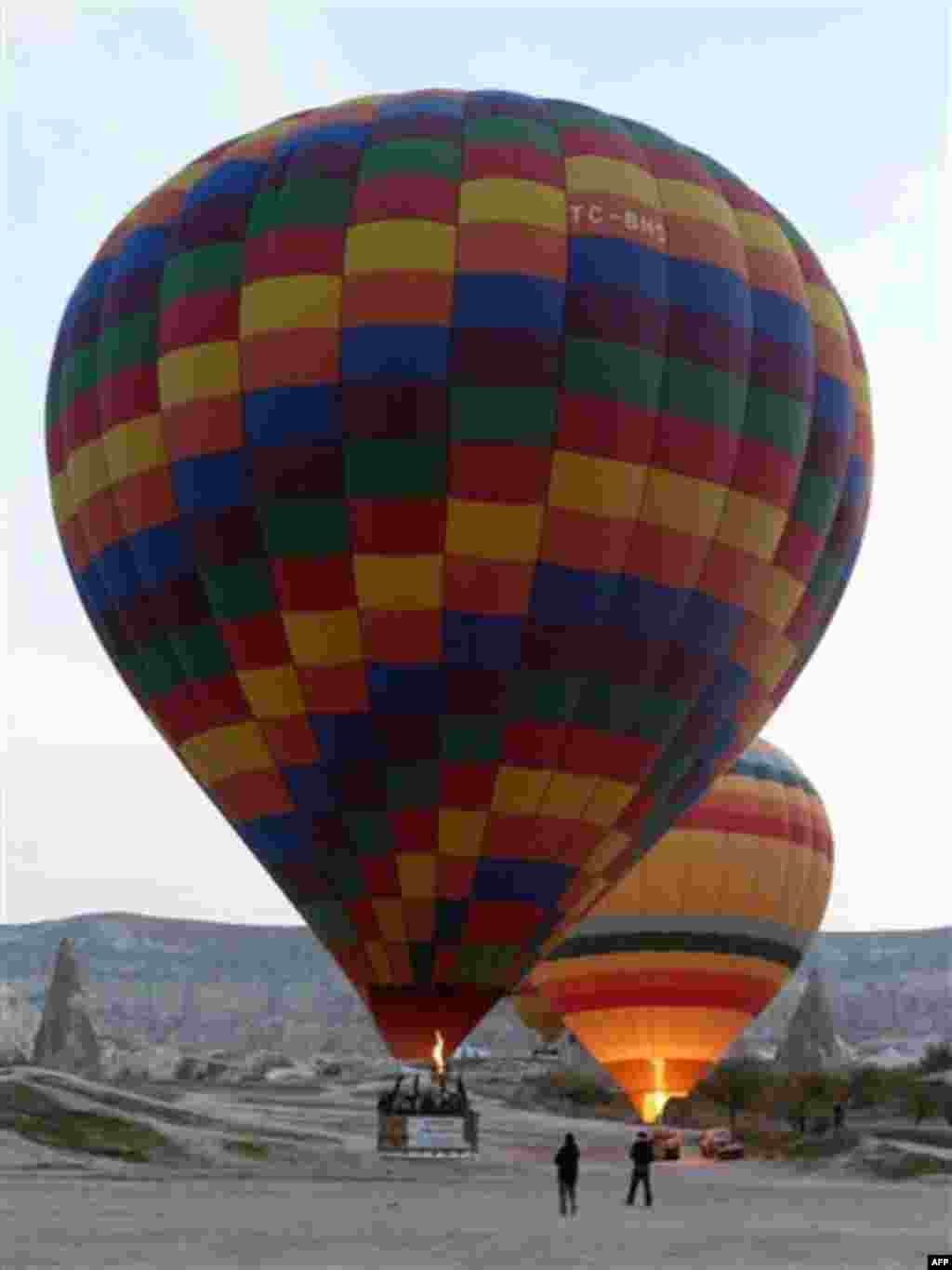 In this photo dated Nov. 15, 2010, hot air balloons rise into the sky at sunrise in Cappadocia, central Turkey. Formed by gas bubbling through ash, Cappadocia has become a favorite site for tourists in hot-air balloons who can slowly drift above the "fair