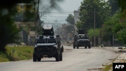 ARCHIVO - Tanques de la policía patrullan el área cercana al Palacio Nacional en Puerto Príncipe, Haití, el 28 de junio de 2024. 