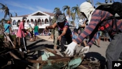 Typhoon survivors and volunteers begin a massive clean up in typhoon-ravaged Tacloban city, Leyte province in central Philippines, Nov. 25, 2013. 