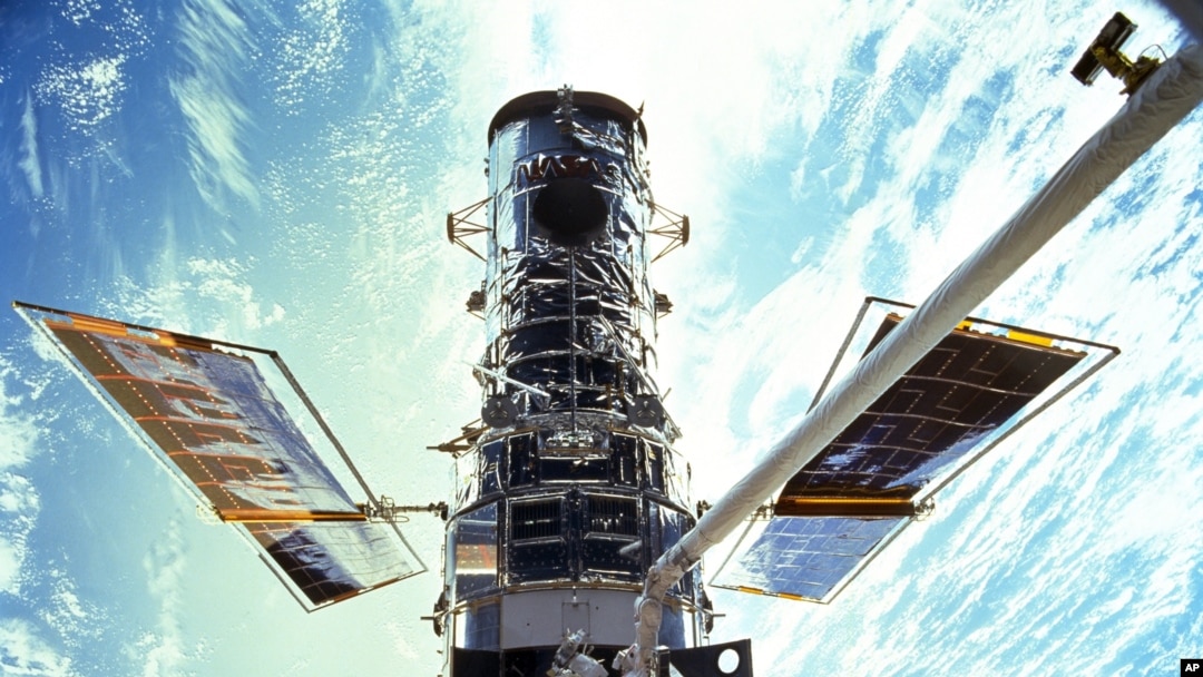En esta imagen provista por la NASA, los astronautas Steven Smith y John Grunsfeld realizan trabajos de mantenimiento del Telescopio Espacial Hubble en diciembre de 1999. 