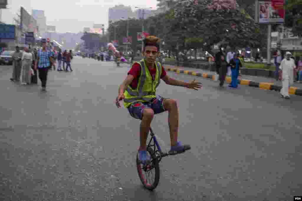 Seorang pemuda Mesir mengendarai sepeda roda satu di lapangan Mostafa Mahmoud menuju tempat sholat Idul Fitri di Kairo, Mesir, 25 Juni 2017. (H. Elrasam/VOA)